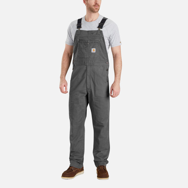 Salopette de travail Carhartt extensible en coton robuste, avec plusieurs poches et bretelles ajustables.