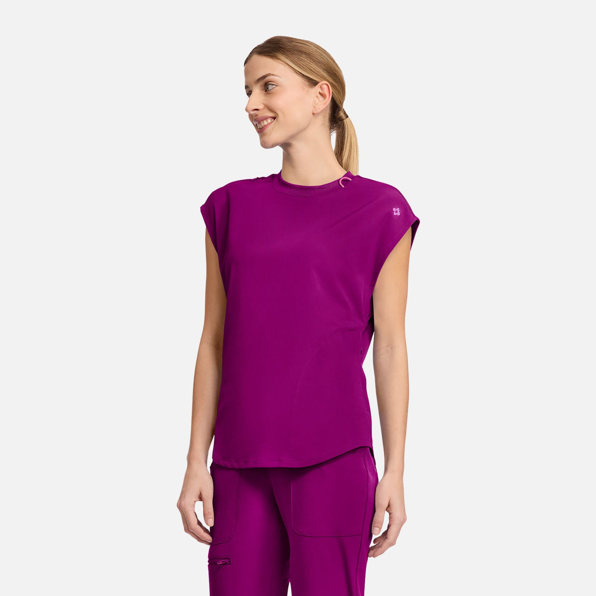 Haut médical à col rond MedCouture, vêtement uniforme moderne pour professionnels de santé, couleur rose pâle.