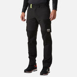 Pantalon cargo noir Helly Hansen pour le travail, conçu pour la mobilité et le confort au travail, en tissu durable.