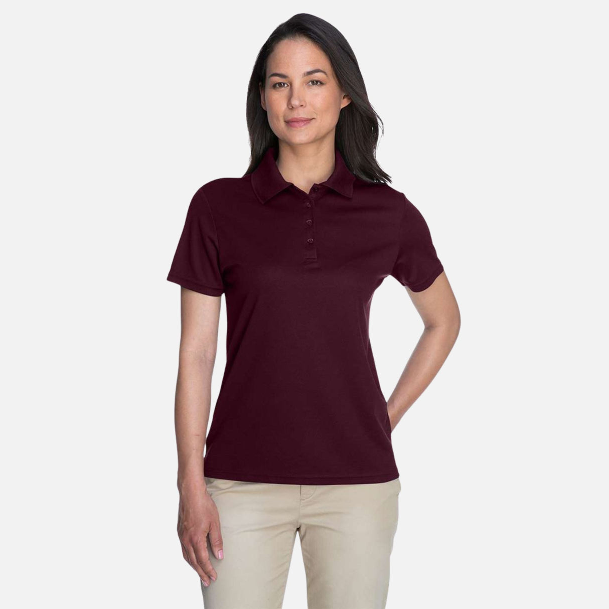 Polo pour femme Core365 Performance Origin en marron, vêtement polo, tissu performant, porté par une femme.