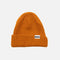 Tuque orange HUSKY L'Essentiel, accessoire chaud en laine avec logo, portée en extérieur par temps froid.