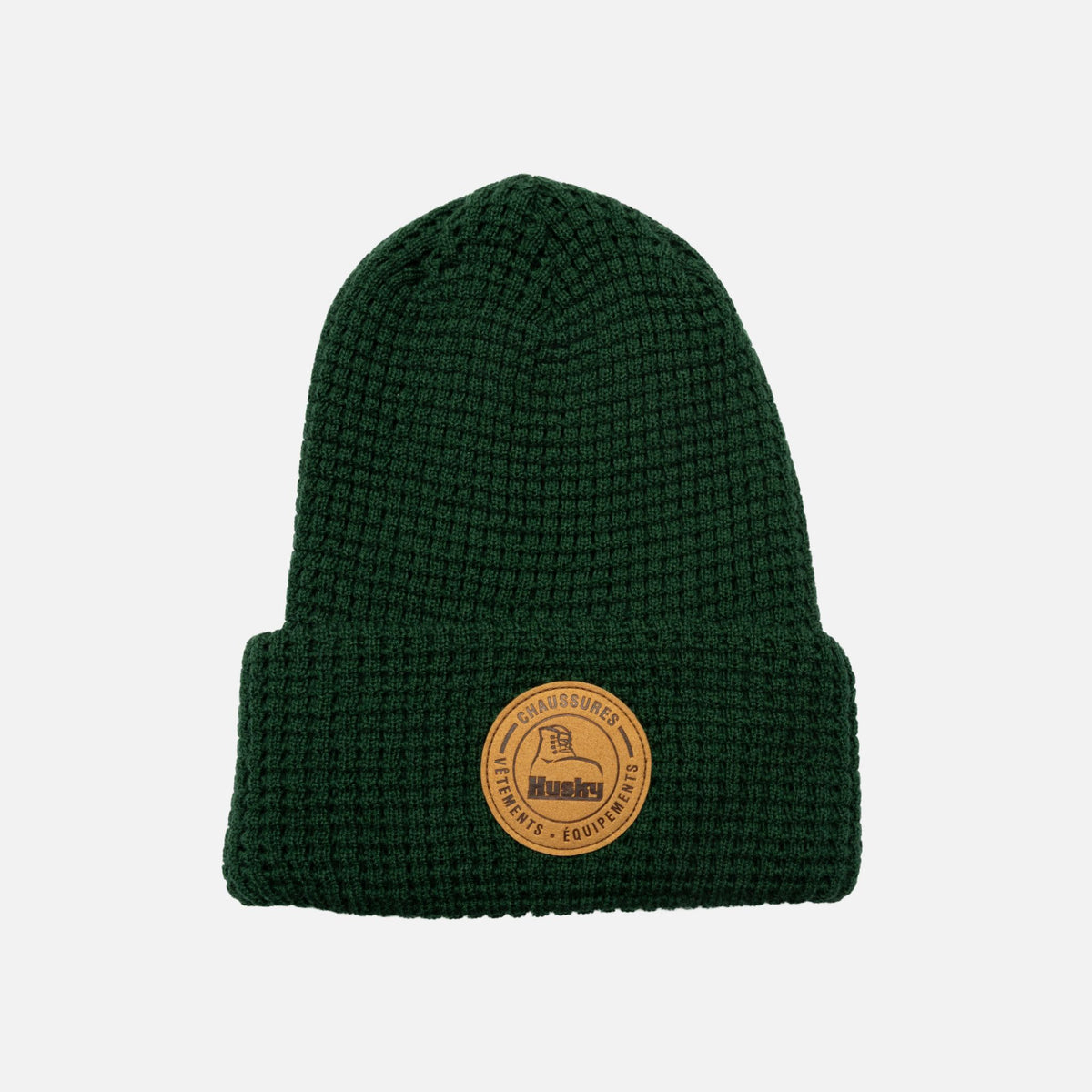 Tuque verte HUSKY L'Essentiel, accessoire d'hiver en laine douce, avec logo brodé, portée en extérieur.